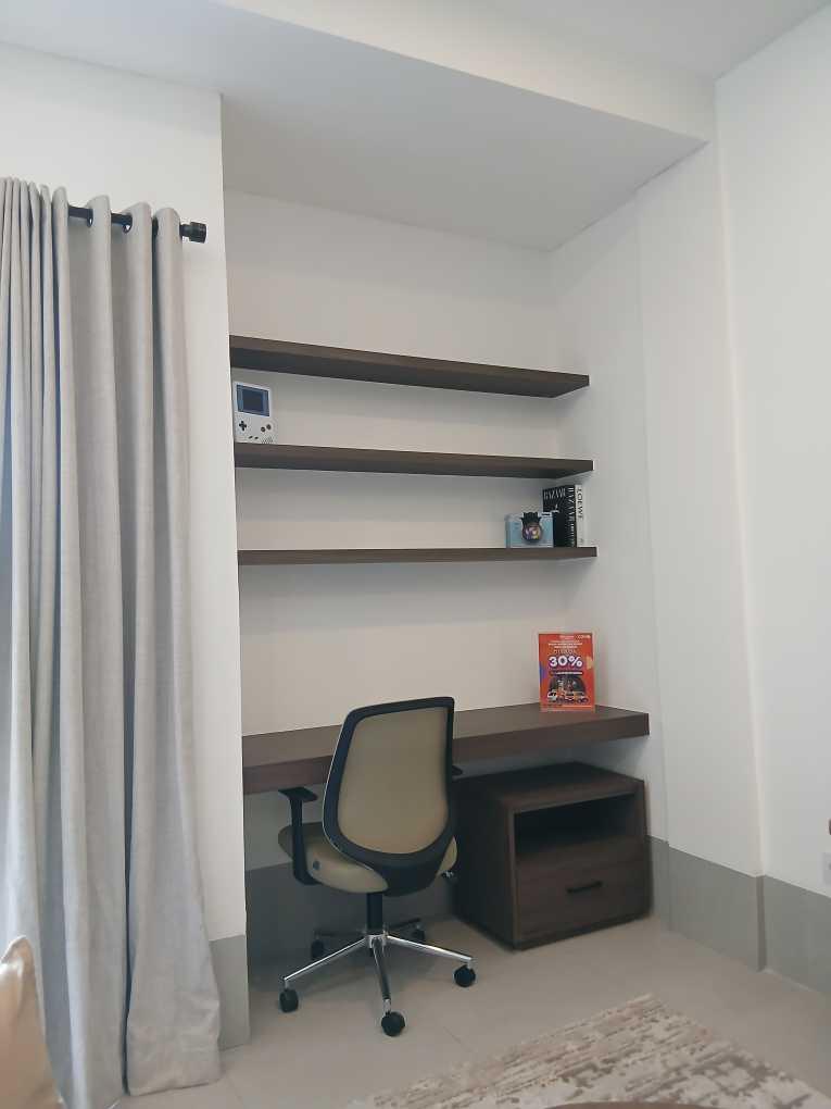 Area kerja minimalis dalam kamar co-living Cove dengan meja kecil dan laptop terbuka, cocok untuk bekerja dari rumah dengan nyaman.